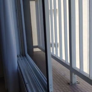 חלון אלומיניום פתוח עם מסגרת ומעקה חיצוני