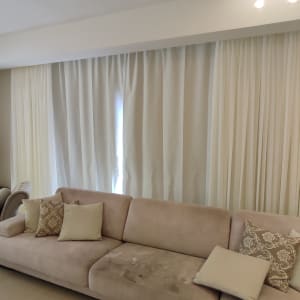 וילון לבן גדול תלוי על הקיר בסלון