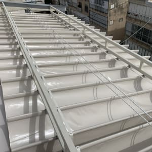 סוכך מתכת עם כיסוי בד לבן על גג