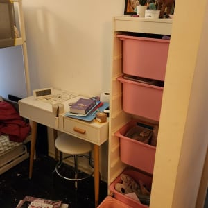 שולחן כתיבה עם מגירות ורודות, ספרים וצעצועים