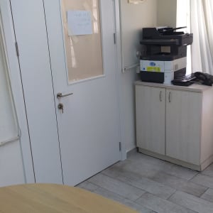 דלת לבנה עם חלון קטן ומנעול כסוף