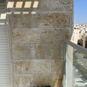 ברז מים מותקן על קיר אבן במרפסת