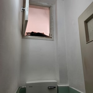 חלון פתוח עם אור נורה בחדר קטן