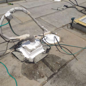 צינורות אטומים בחומר לבן על גג בטון