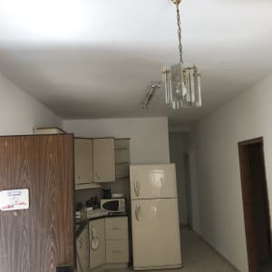 מטבח עם מקרר, ארונות ותאורה עליונה