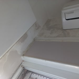 קיר עם סימני צבע מתקלף ליד מזגן