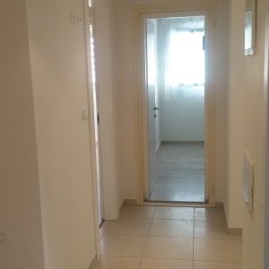 מסדרון עם קירות צבועים בלבן ודלתות פתוחות