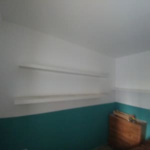 מדפים לבנים מותקנים על קיר לבן