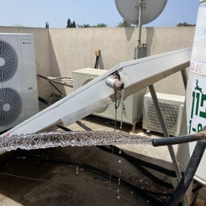 צינור מים מטפטף מחובר לדוד שמש על גג