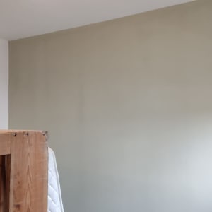 קיר צבוע בצבע בהיר עם רהיט מכוסה בניילון