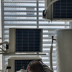 אדם עובד על מערכת מיזוג אוויר עם צינורות