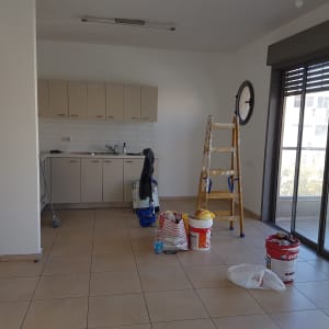 סולם, דלי צבע ומברשת בחדר ריק