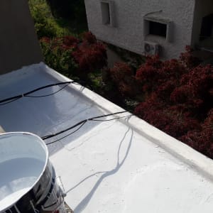 גג אטום בצבע לבן עם דלי צבע פתוח