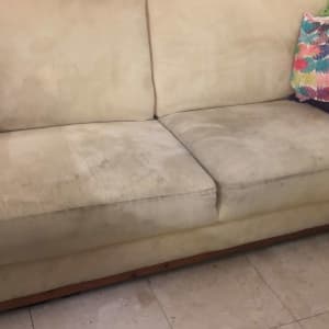 ספה מלוכלכת עם כתמים כהים על הריפוד