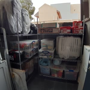 מדפים עם קופסאות פלסטיק, צבעים וכלי עבודה