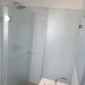 מקלחת עם דלת זכוכית וברז מתכת