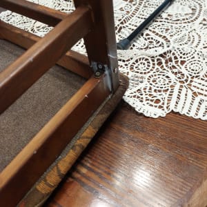 כיסא עץ הפוך עם ברגים ומברג על שולחן