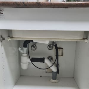 צנרת מתחת לכיור עם מחבר פלסטיק לבן