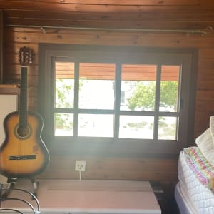 חדר עץ עם חלון, גיטרה ותמונה על הקיר