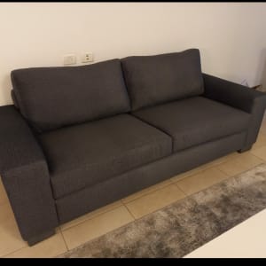 ספה אפורה עם ריפוד מרופד ושתי כריות גב