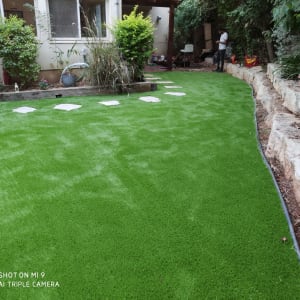 דשא סינתטי עם אבנים בשביל בגינה