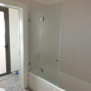 דלת זכוכית למקלחת על אמבטיה לבנה