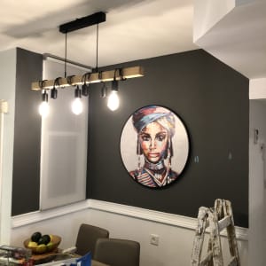 ציור פורטרט צבעוני של אישה על קיר אפור