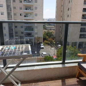 מעקה זכוכית במרפסת עם נוף לבניינים