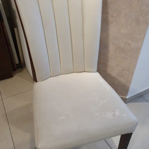כיסא מרופד בלבן עם קרעים בבד