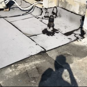 גג עם יריעות איטום וחומרי זפת שחורים