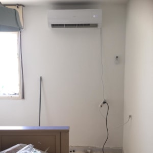 מזגן מותקן על קיר עם שלט רחוק מחובר לחשמל