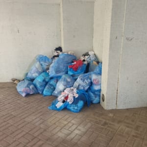 שקיות כחולות מלאות בבגדים מונחות על הרצפה