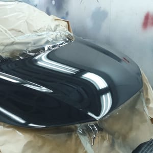 מכסה מנוע צבוע בשחור מבריק עם נייר מגן