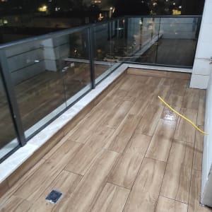 מרפסת עם רצפה רטובה וצינור צהוב לניקוי