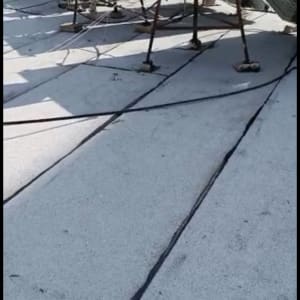 גג עם יריעות איטום שחורות ומיכלים לבנים