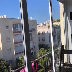 מסגרת חלון אלומיניום עם נוף עירוני ברקע