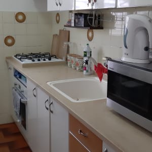 מטבח עם ארונות לבנים, כיור ותנור אפייה