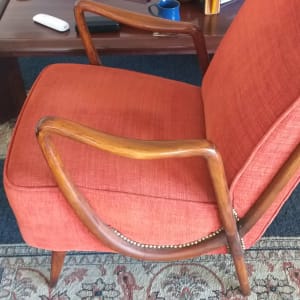 כיסא מרופד כתום עם ידיות עץ