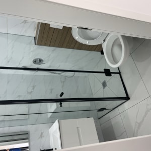 חדר אמבטיה עם מקלחון, אסלה ורצפה נקייה