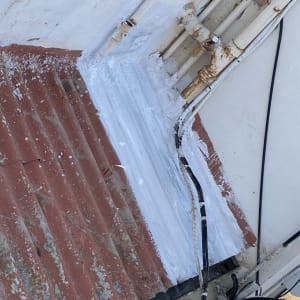 איטום גג עם חומר לבן סביב צינורות וחוטים