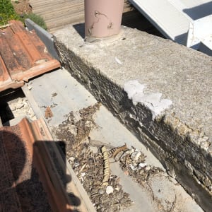 גג עם רעפים אדומים, צינור ורוד ולכלוך