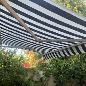 סוכך פסים שחור לבן בגינה ירוקה