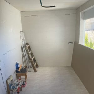 חדר בבנייה עם סולם, כבלים וכלי עבודה