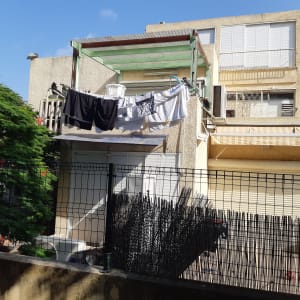 חבלי כביסה עם בגדים תלויים על מרפסת בית