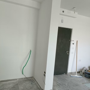 קיר גבס עם חוטים חשמליים חשופים וצינור ירוק