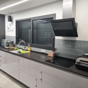 זכוכית מגן על הקיר מעל השיש במטבח מודרני
