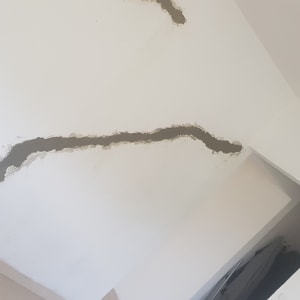 קיר לבן עם סדק מתוקן בטיח אפור