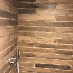 מקלחת עם אריחי עץ וברז מתכת מודרני
