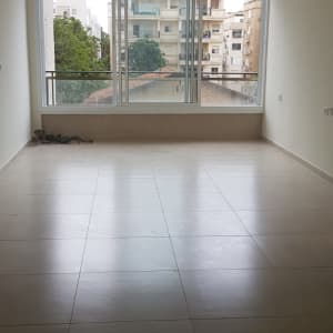 חדר ריק עם רצפת אריחים וחלון גדול