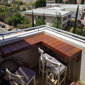 שולחן עץ פינתי עם כיסאות במרפסת